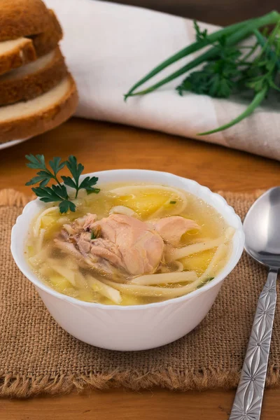 Erişte çorbası tavuk ve patates maydanoz yaprakları, bir çorba kaşığı keten peçeteye.