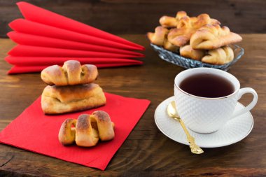 Kahvaltı kıvırcık pasta doldurma, bir beyaz Porselen Kupa çay ahşap arka plan üzerinde kırmızı peçeteler ile hizmet veren.