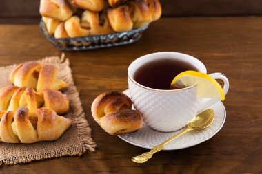 Doldurma, ahşap arka plan beyaz bir kupa limonlu çay ile hamur işleri, Kahvaltı.