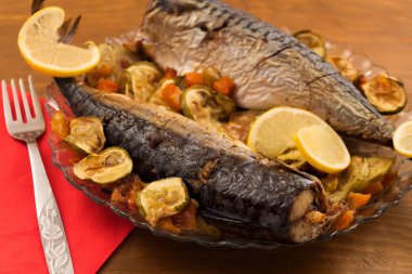 Balık yemek sebze ve limon dilimleri ile kızarmış uskumru götürüyor.