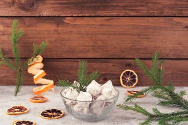 Çikolata şekerleme Beyaz pudra şekeri, Noel süsleri çam dalları, kurutulmuş limon dilimleri, ahşap arka plan.