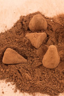 Kakao tozu, ahşap arka plan, dikey çerçeve ile çikolata truffles serpin.