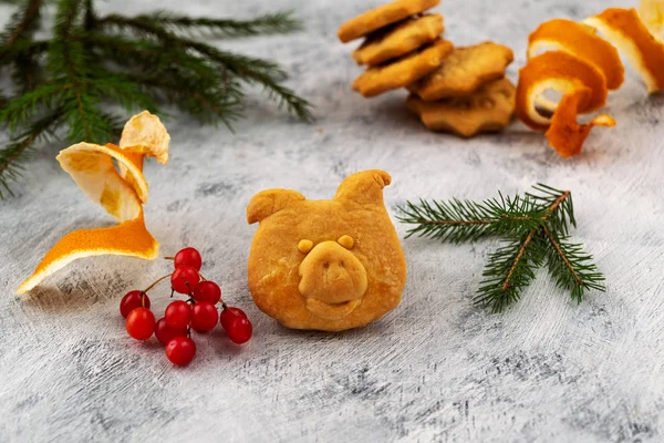 Baked pig\'s head made of dough, red viburnum berries, cut lemon peel in the form of a spiral, Christmas card.