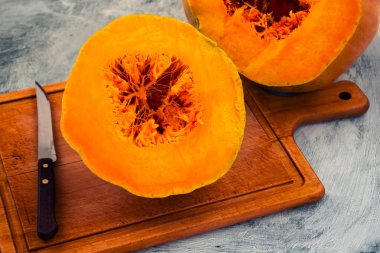 Olgun kabak, iki bölümden, portakal eti ve çekirdeği lif içine bir bıçak ile kesmek.