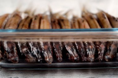 Deniz balığı sıkıca bir katmanda altta koydu bir cam kap içinde.