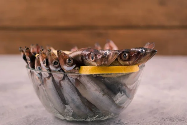 新鲜的卡佩林 小海鱼 在一个圆形的玻璃碗里放一片柠檬 — 图库照片
