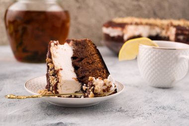 Çocuk oyuncağı bir plaka tarafında. Kahverengi ve beyaz tabaka. Kaşık ve pasta. Tatlı yeme. Kupası dilim limon ile. Açık renkli.
