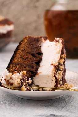 Çikolatalı kek bir tabağa dilimlenmiş. Dikey. Kahverengi ve beyaz tabaka. İçki sürahi.