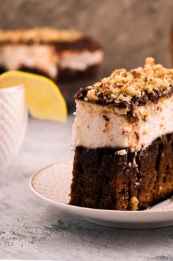 Çikolatalı pasta dilimlenmiş bir parçası. Beyaz krem tabakası. Ezilmiş ceviz. Dikey. Açık renkli.