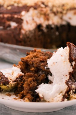 Yarısı yenmiş kek kalıntıları. Kahverengi ve beyaz tabaka. Dikey.