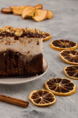 Çikolatalı kek ile fındık yakın çekim. Kabuk tarçın, kurutulmuş limon dilimleri. Dikey. Açık renkli.