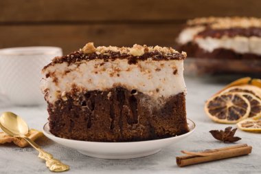 Bir dilim pasta beyaz beze ile. Tarçın çubuğu, Kuru limon dilimleri çay kaşığı. Açık renkli.