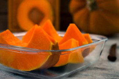 Olgun kabak parçaları. Turuncu hamuru. Pişirme için cam kap. Açık renkli.