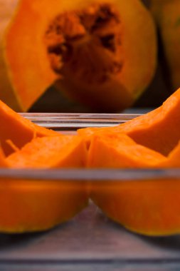 Bir cam kase çiğ kabak parçaları. Dikey. Dilimlenmiş olgun kabak içinde belgili tanımlık geçmiş. Turuncu hamuru.