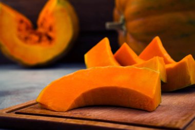 Dilimlenmiş kabak. Olgun turuncu ortasında. Ahşap tahta. Açık renkli. Vejetaryen yiyecekler.