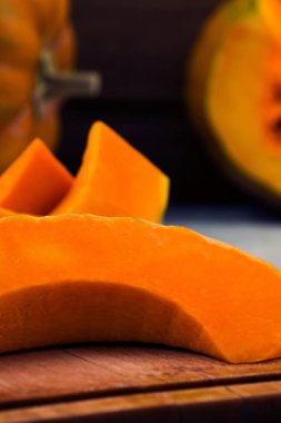 Bir ahşap tahta üzerinde olgunlaşmış kabak parçası. Dikey. Yakın çekim. Çiğ sebze. Vejetaryen yiyecekler.