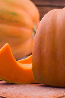 Olgun kabak, parçalar halinde kesilmiş. Dikey. Ahşap arka plan.
