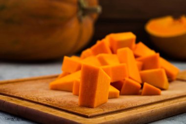 Olgun kabak parçaları dilimlenmiş. Olgun meyve portakal eti. Mutfak tahta kesme. Ahşap arka plan. Çiğ sebze.