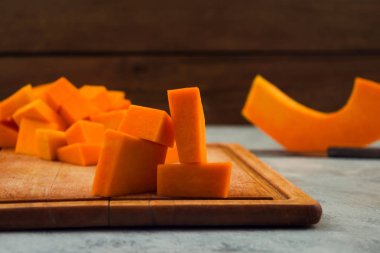 Olgun kabak dilimlenmiş. Meyve portakal hamuru. Ahşap arka plan. Çiğ sebze. Vejetaryen yiyecekler.