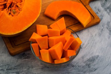 Kabak daha fazla hazırlık için dilimleme. Dilim ve turuncu etin küçük parçalar. Vejetaryen yiyecekler. Çiğ sebze. Açık renkli.