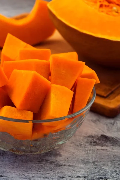 Yuvarlak cam kase kabak dilimleri ile. Olgun meyve portakal eti. Dikey. Vejetaryen yiyecekler. Çiğ sebze.