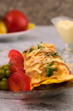 Omlet rulo. Dilimlenmiş domates Marine yeşil bezelye. Dikey. Açık renkli.