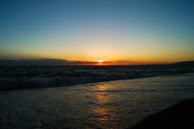 Güneş ufukta denizde batacak. Günbatımı okyanus üzerinde. Güneş ışığı su yansıması.
