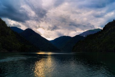 Dağların göl. Sudaki yansıması ile gün batımı. Thunderclouds gökyüzünde. Akşam manzara. Alacakaranlık Gölü.