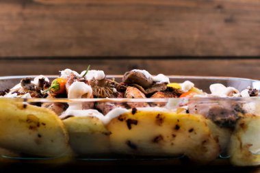 Fırında mantar patates ile. Sebze ile pişmiş yemek. Ahşap arka plan. Pişirme için Züccaciye Mağazaları.