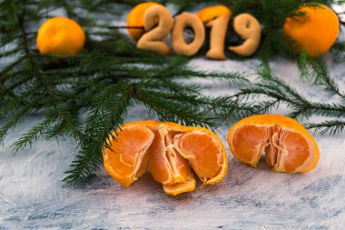 Mandalina ve çam dalları. 2019. açık renkli. Olgunlaşmış tropikal meyve. Portakal dilimleri. Noel hikayesi.