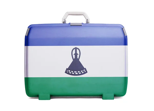 Used plastic suitcase with stains and scratches, printed with flag, Lesotho