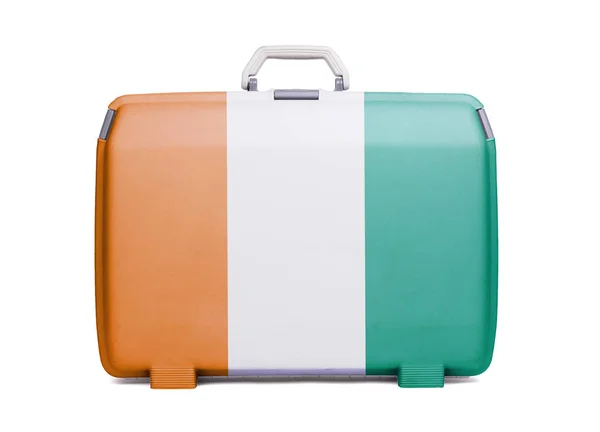 Used plastic suitcase with stains and scratches, printed with flag, Ivory Coast