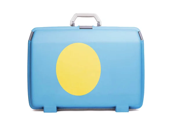 Used plastic suitcase with stains and scratches, printed with flag, Palau