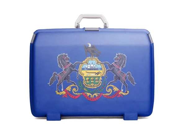 Used plastic suitcase with stains and scratches, printed with flag, Pennsylvania