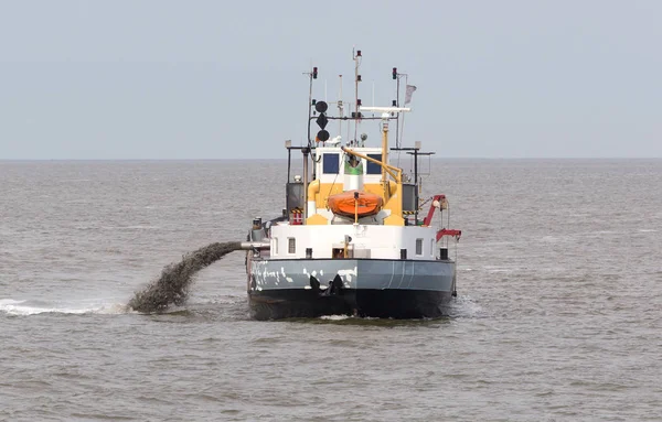 从海岸海岸线到泵砂 Waddensea 的砂疏浚船 — 图库照片