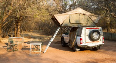 Çölde kamp için çatıda çadırları olan 4x4 Offroad aracı hazır.