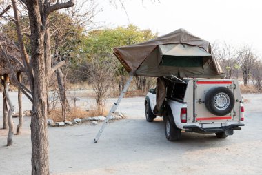 Çölde kamp için çatıda çadırları olan 4x4 Offroad aracı hazır.