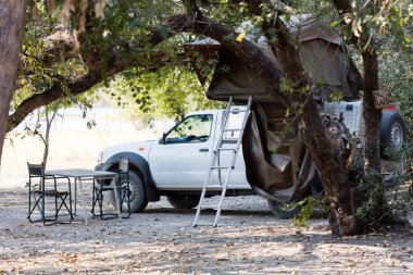 Çölde kamp için çatıda çadırları olan 4x4 Offroad aracı hazır.