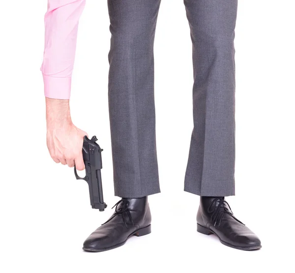 Businessman shooting himself in the foot with a handgun — Stock Photo, Image