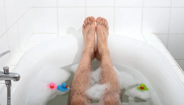 Men\'s feet in a bathtub, selective focus on toes