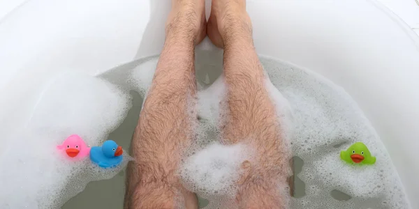 男人的脚在明亮的白色浴缸里 有选择地专注于脚趾 — 图库照片