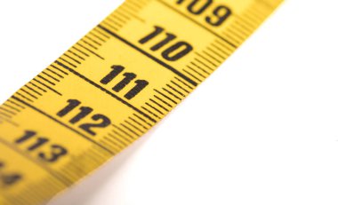 Beyaz üzerine izole edilmiş sarı bir ölçüm bandının yakın çekimi - 111 - Seçici odak