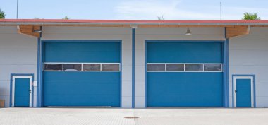 Büyük mavi kapılı ticari bina.