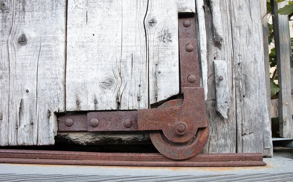 Sıkıntılı Ahır Kapısı Paslı Bir Tekerleğe Seçici Odaklanma — Stok fotoğraf