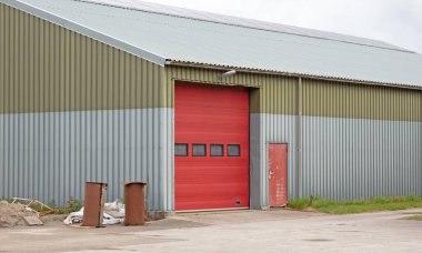 Kırmızı kapılı büyük bir kulübe, büyük araçlar için.