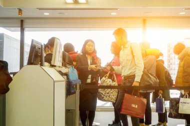 Osaka, Japonya 21 Şubat 2018: turist yürümek satırında ve personel incelemek yatılı Kansai Uluslararası Havaalanı Terminal önce havayolu için pasaport göstermek.