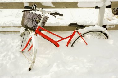 Çit Park ve ağır bir kar fırtınası kardan kapalı kırmızı Bayan Bisiklet.