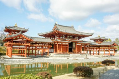 Perspektif görünümü parlak mavi gökyüzü bulutlu altında gölet ve Byodion Japon Budist Tapınağı. Byodion Tapınağı on yedi Japon Dünya Miras Unesco, biridir. Bulunan Uji, Kyoto, Japonya.