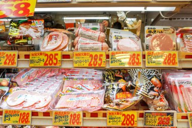 OSAKA, JAPAN, February 19, 2018 : Closeup hams and processed meat in packs for sale in Japan supermarket's freezer. clipart