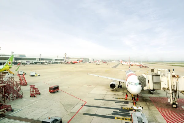 Bangkok, Tayland 11 Şubat 2018: manzaralı Don Mueang Uluslararası Havaalanı Tayland uçak ile gelir ve park dış Terminal sunar yolcu jet bridge ile parlak mavi gökyüzü altında.